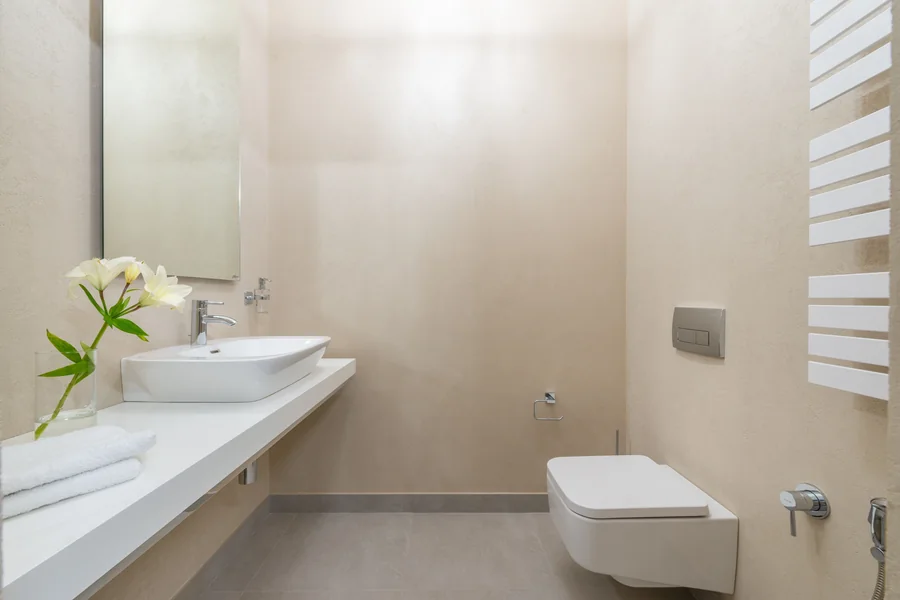 Baño terminado con lavabo blanco, llave cromada e inodoro suspendido.