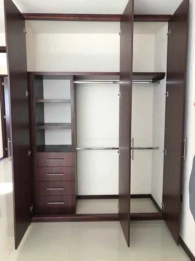 Closet en tono chocolate con las puertas abiertas: cajonera, entrepaños y dos tubos para colgar