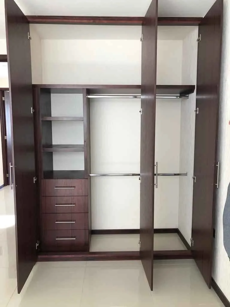 Closet en tono chocolate con las puertas abiertas: cajonera, entrepaños y dos tubos para colgar