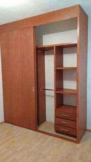 Closet en tono cerezo con puerta corrediza, cajones y entrepaños