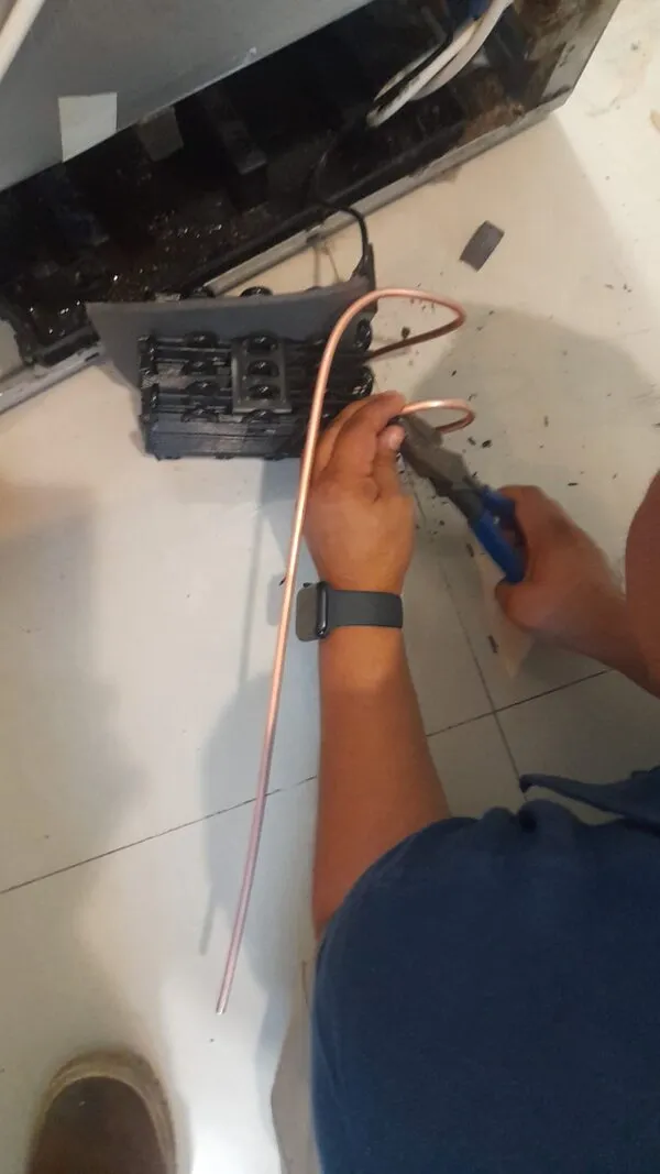 Técnico de Servicom reparando la tubería de cobre de un refrigerador